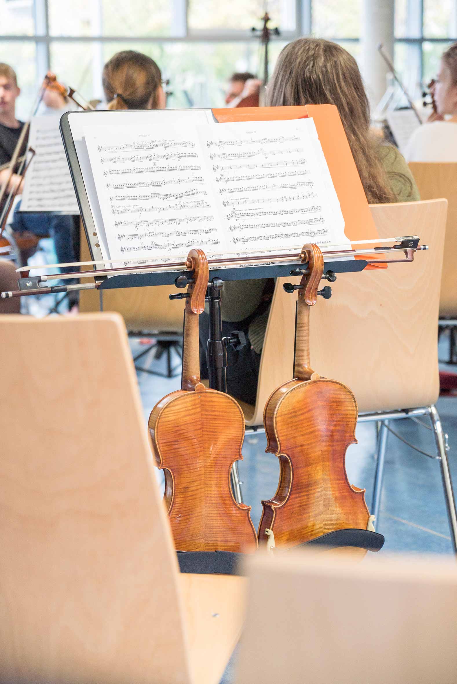 Konzertfotografie von Junge Philharmonie Würzburg. Geigen hängen an Notenständer