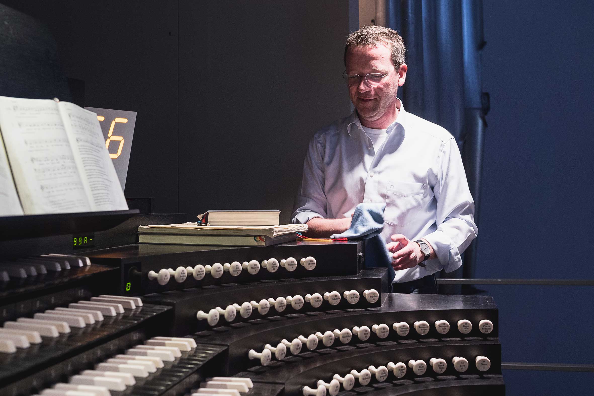 Domorganist Stefan Schmidt wischt Staub auf der Orgel in Würzburg